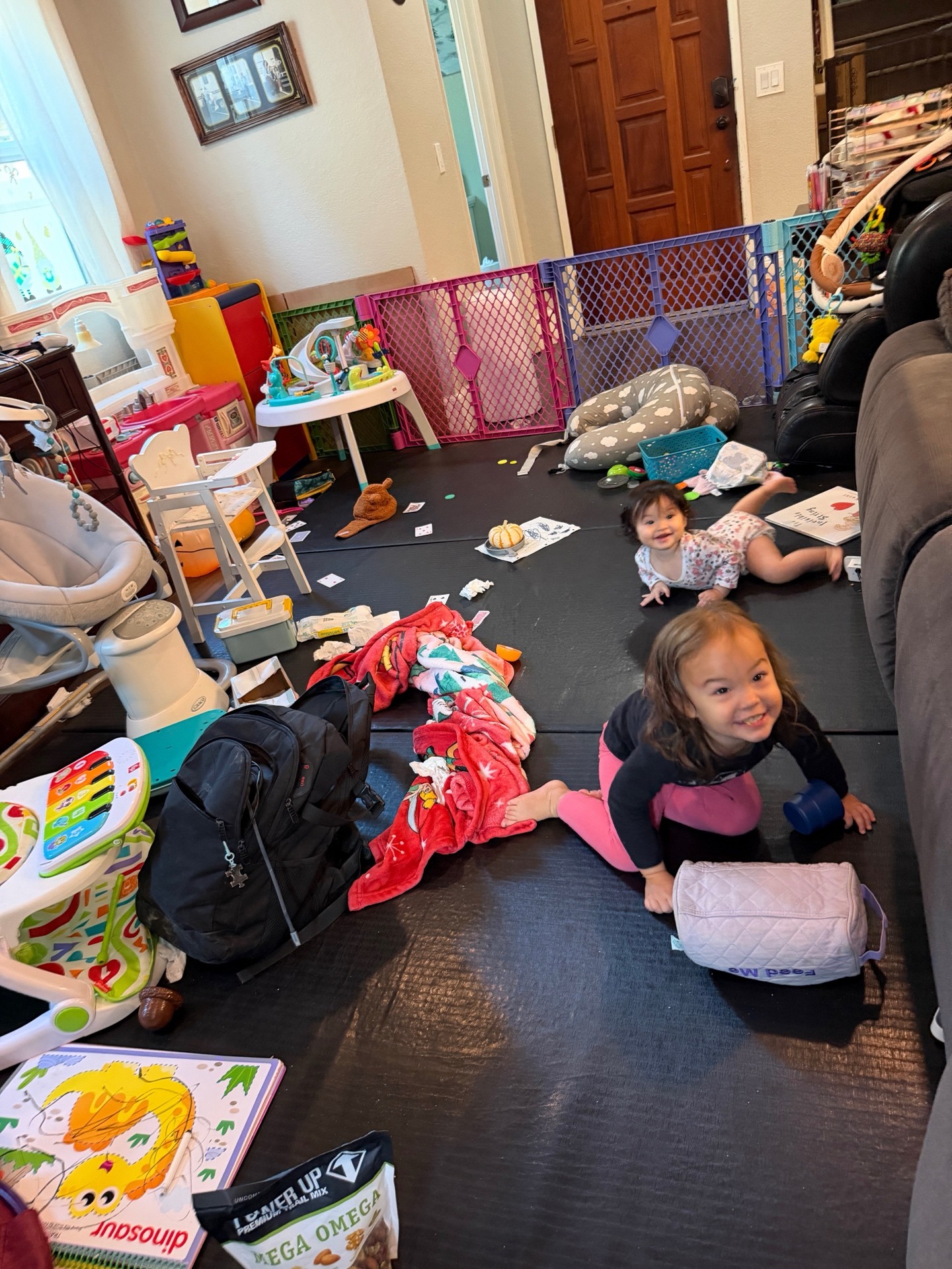 Children playing among toys and training mats in a home living room, illustrating an unpredictable environment.