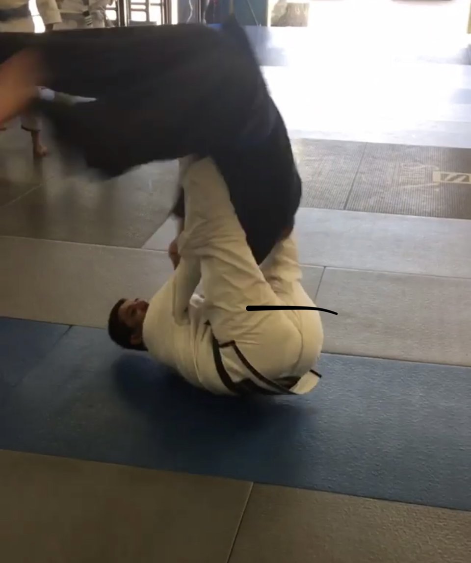 Paulo Fernando continuing a signature takedown demonstration on the mat.