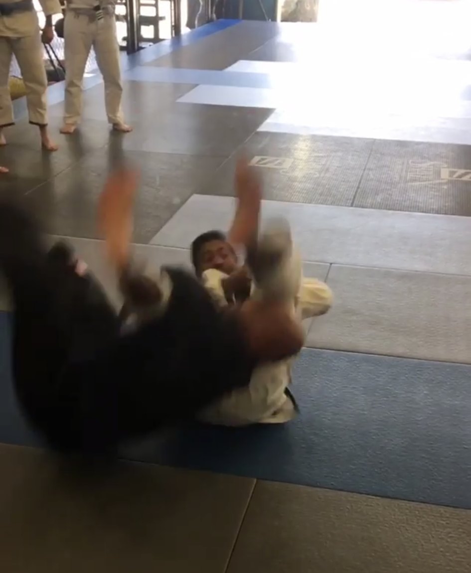 Paulo Fernando completing a signature takedown demonstration on the mat.